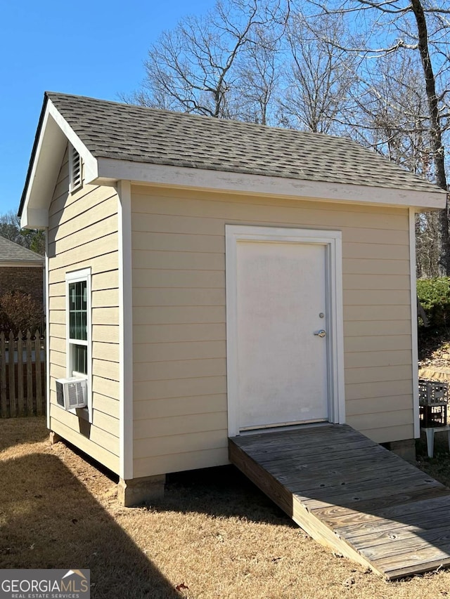 view of shed with cooling unit and fence