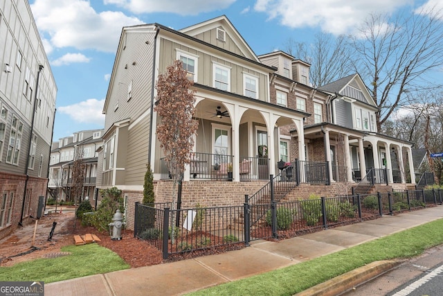 multi unit property with a fenced front yard, covered porch, board and batten siding, and brick siding