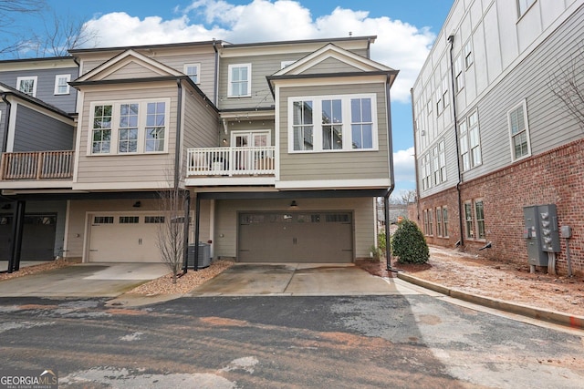 townhome / multi-family property featuring a garage, cooling unit, and driveway