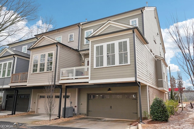 back of house featuring concrete driveway, brick siding, a garage, and central AC