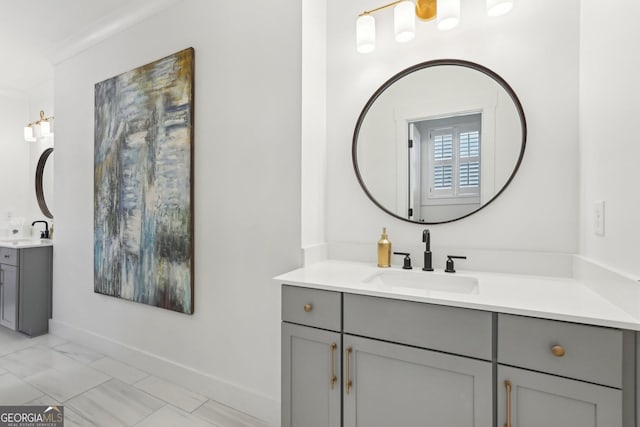 bathroom featuring a sink, baseboards, marble finish floor, and two vanities