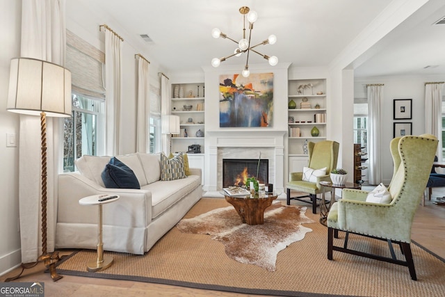 living area with a wealth of natural light, built in features, and a warm lit fireplace