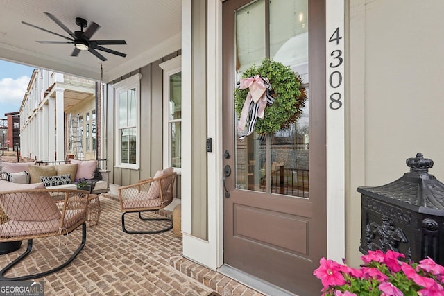 view of exterior entry featuring an outdoor living space, a ceiling fan, and covered porch