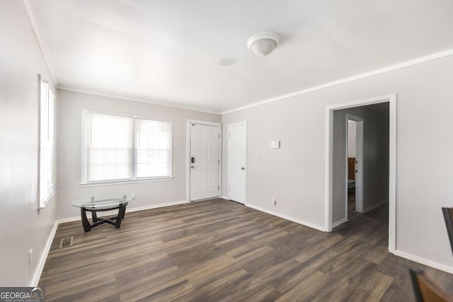 entrance foyer with ornamental molding, visible vents, dark wood finished floors, and baseboards