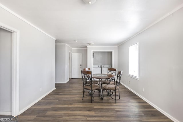 dining room featuring dark wood-type flooring, independent washer and dryer, crown molding, and baseboards