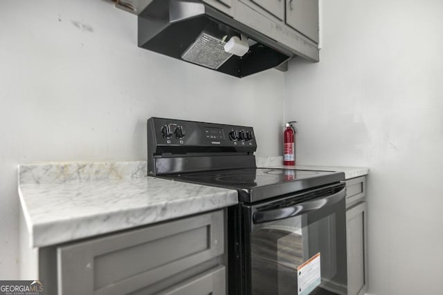 kitchen with black electric range, gray cabinets, light countertops, and under cabinet range hood