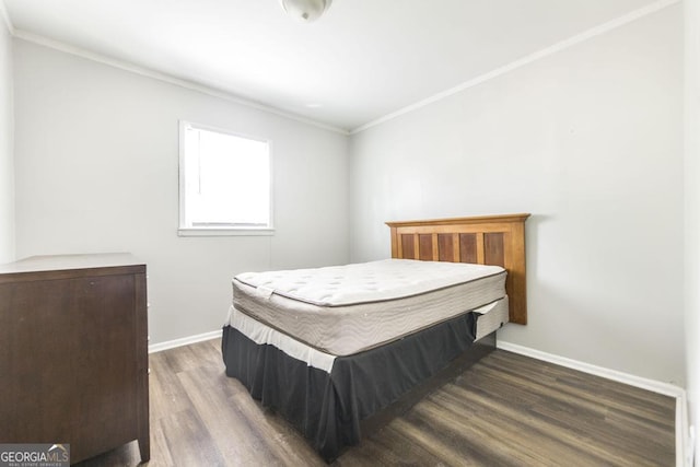 bedroom featuring crown molding, baseboards, and wood finished floors