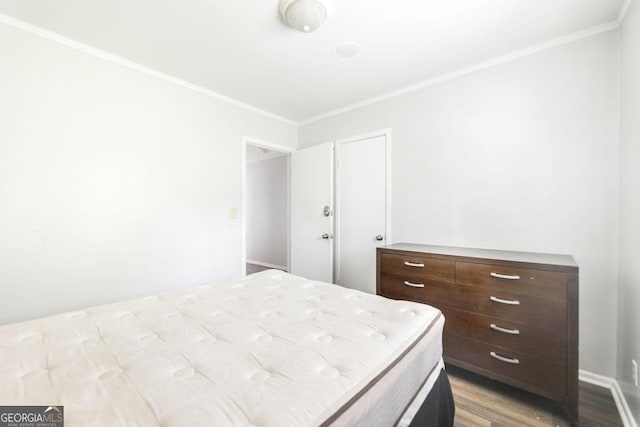 bedroom with crown molding and wood finished floors