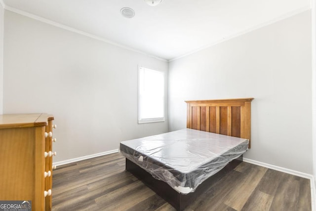 bedroom with dark wood-style floors, ornamental molding, and baseboards