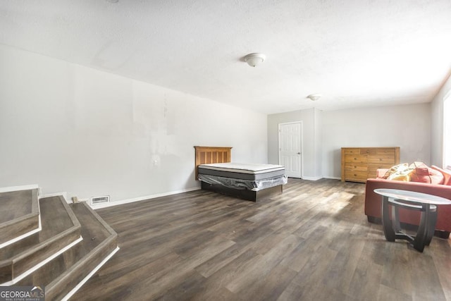 bedroom featuring visible vents, baseboards, and wood finished floors