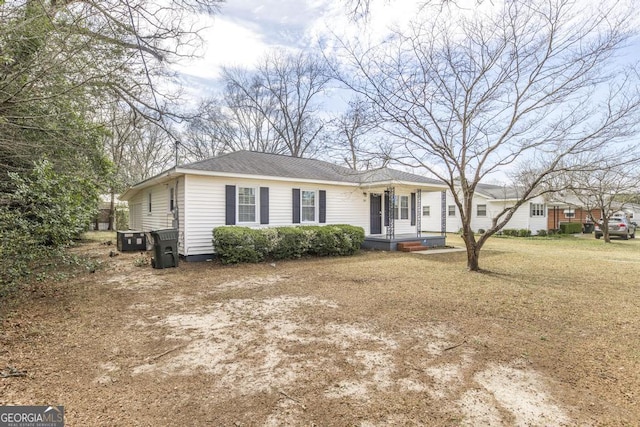 single story home with a shingled roof and a front yard