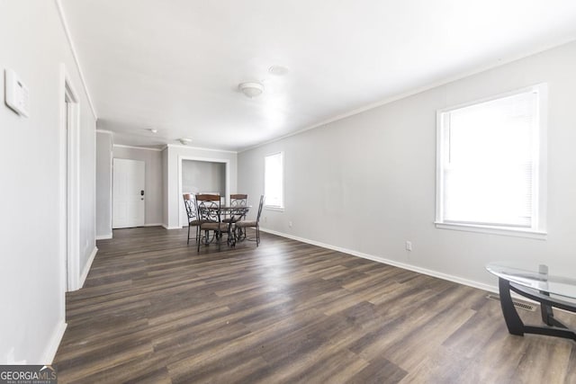 dining space featuring dark wood-style floors, visible vents, baseboards, and crown molding