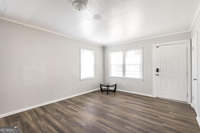 interior space featuring crown molding, dark wood-type flooring, and baseboards