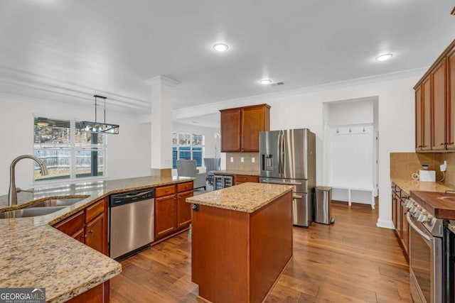 kitchen featuring light stone counters, dark wood-style flooring, stainless steel appliances, and a sink