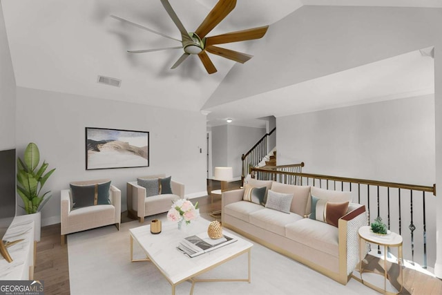 living room featuring visible vents, ceiling fan, wood finished floors, high vaulted ceiling, and stairs