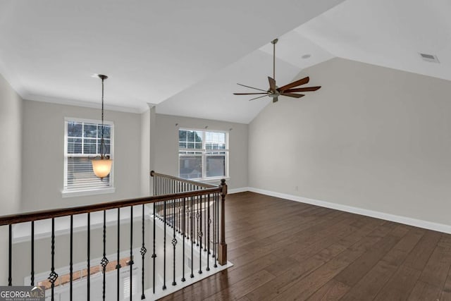 corridor with wood finished floors, an upstairs landing, visible vents, vaulted ceiling, and baseboards