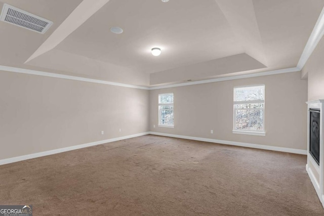 unfurnished living room with a tray ceiling, carpet, a fireplace, visible vents, and baseboards