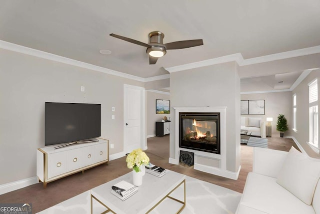 living room featuring ornamental molding, baseboards, ceiling fan, and a multi sided fireplace