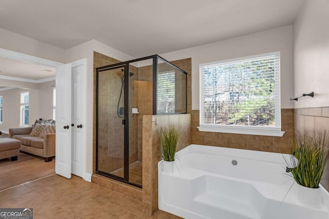 ensuite bathroom featuring a garden tub, a shower stall, a wealth of natural light, and ensuite bathroom