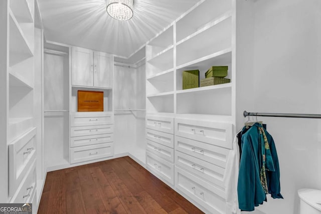 walk in closet featuring dark wood-type flooring and a chandelier