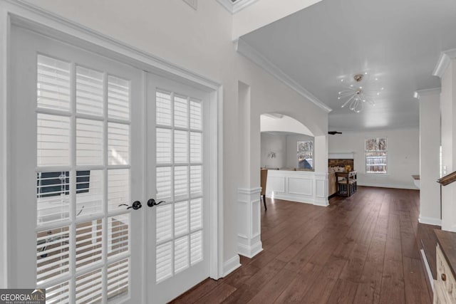 hall featuring dark wood-style floors, arched walkways, french doors, and crown molding