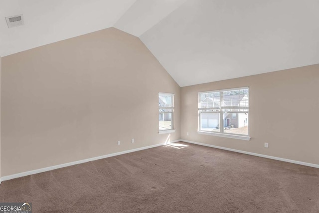 carpeted empty room with high vaulted ceiling, visible vents, and baseboards