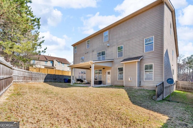 back of house with a fenced backyard, a patio, and a yard