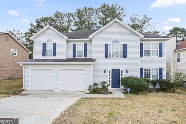 view of front of property with a garage, concrete driveway, and a front lawn