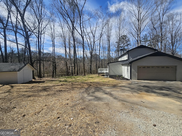 view of home's exterior with an attached garage and dirt driveway