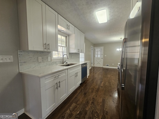 kitchen with decorative backsplash, appliances with stainless steel finishes, dark wood-type flooring, white cabinetry, and a sink