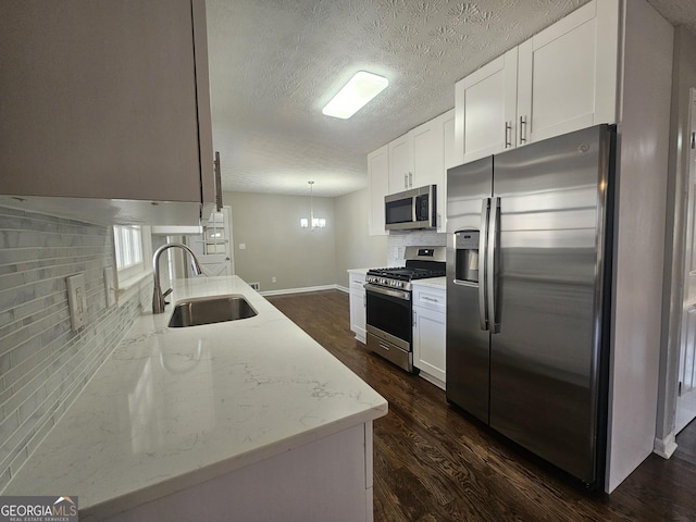 kitchen featuring stainless steel appliances, tasteful backsplash, dark wood-type flooring, and a sink