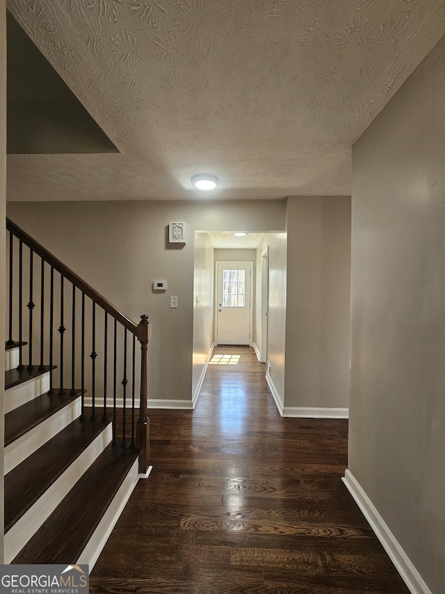 foyer with stairs, baseboards, and wood finished floors