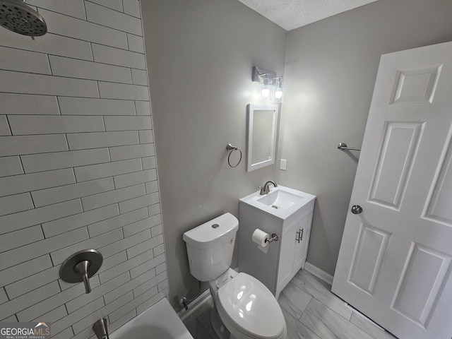 bathroom featuring toilet,  shower combination, a textured ceiling, and vanity