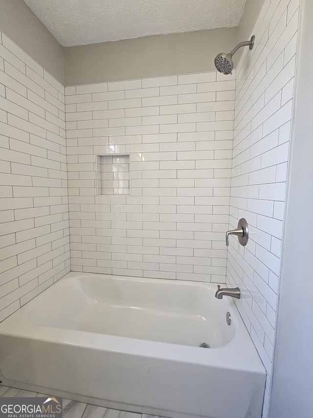 bathroom featuring shower / tub combination and a textured ceiling