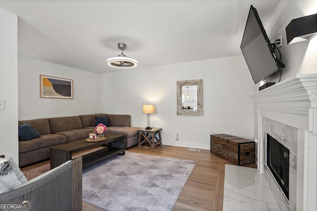 living room with baseboards and a premium fireplace