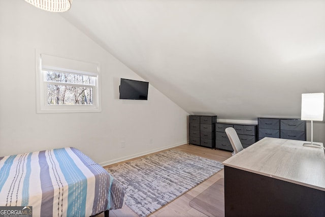 bedroom featuring lofted ceiling, baseboards, and light wood-type flooring