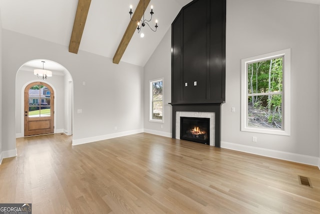 4860 Grandview Ct, Flowery Branch, GA 30542 - unfurnished living room featuring arched walkways, high vaulted ceiling, healthy amount of natural light, light wood-type flooring, and a large fireplace