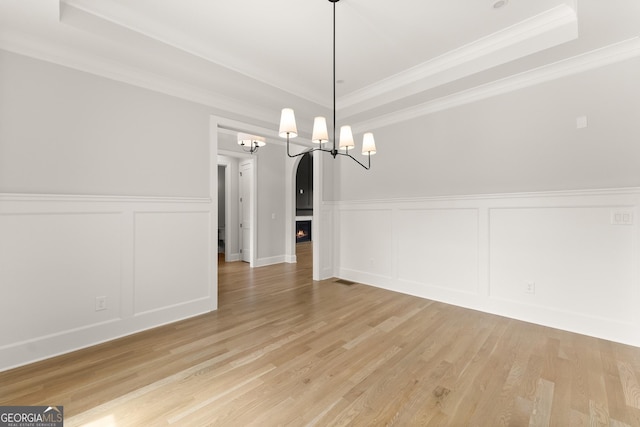 4860 Grandview Ct, Flowery Branch, GA 30542 - unfurnished dining area featuring a decorative wall, a chandelier, a tray ceiling, a wainscoted wall, and light wood-type flooring