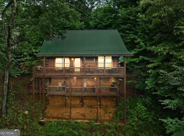 rear view of house featuring metal roof, a deck, and log siding