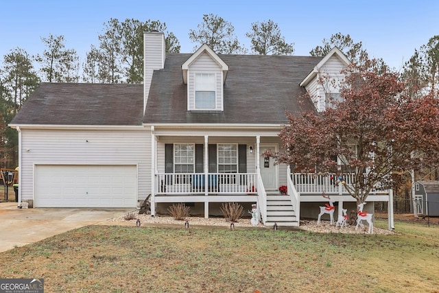 new england style home with concrete driveway, a chimney, an attached garage, covered porch, and a front yard