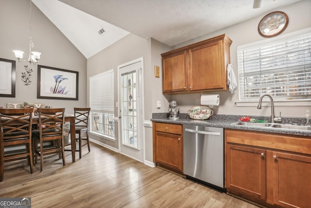 kitchen with visible vents, dishwasher, dark countertops, brown cabinets, and a sink