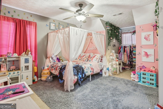 bedroom featuring a ceiling fan, visible vents, a textured ceiling, and carpet floors