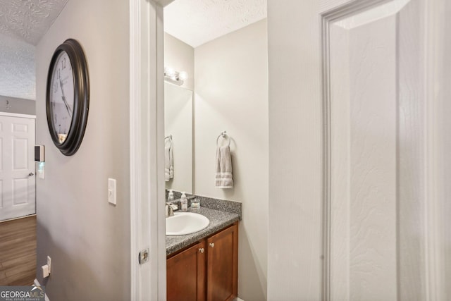 bathroom with a textured ceiling and vanity