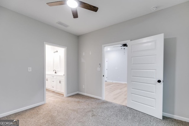 unfurnished bedroom with baseboards, connected bathroom, visible vents, and light colored carpet