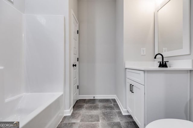 bathroom with toilet, vanity, and baseboards