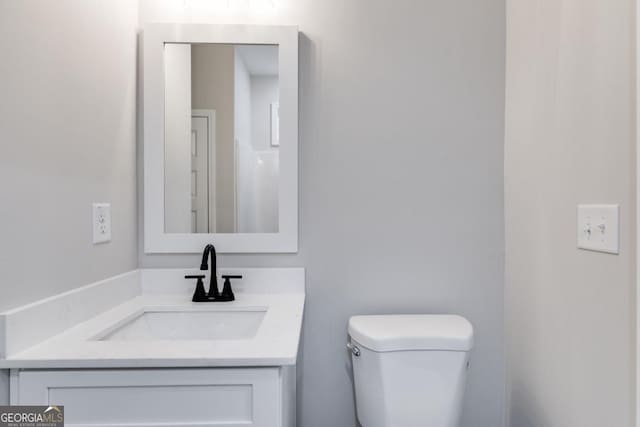 half bathroom with toilet and vanity