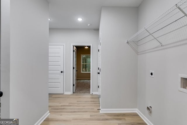 clothes washing area featuring washer hookup, light wood-style floors, electric dryer hookup, laundry area, and baseboards