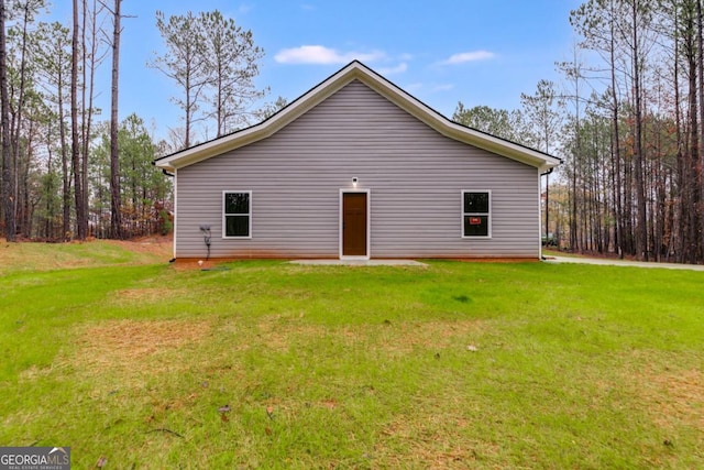 rear view of house featuring a yard