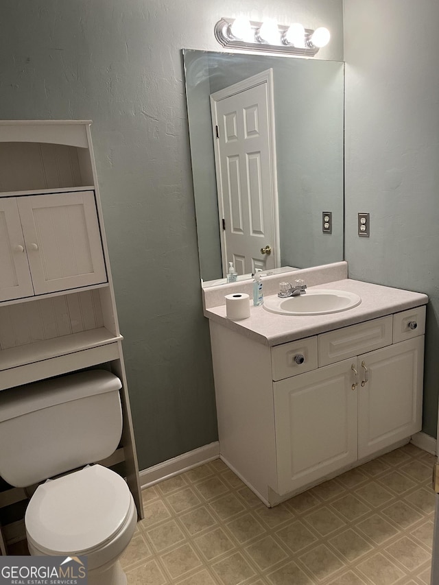 bathroom featuring tile patterned floors, vanity, toilet, and baseboards