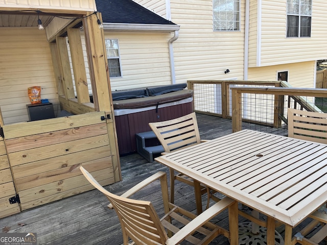 wooden deck featuring outdoor dining area and a hot tub